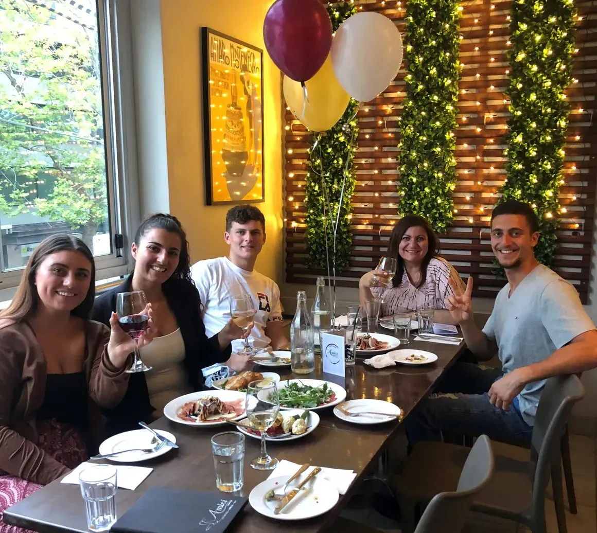 A group of people are sitting at a table with plates of food.