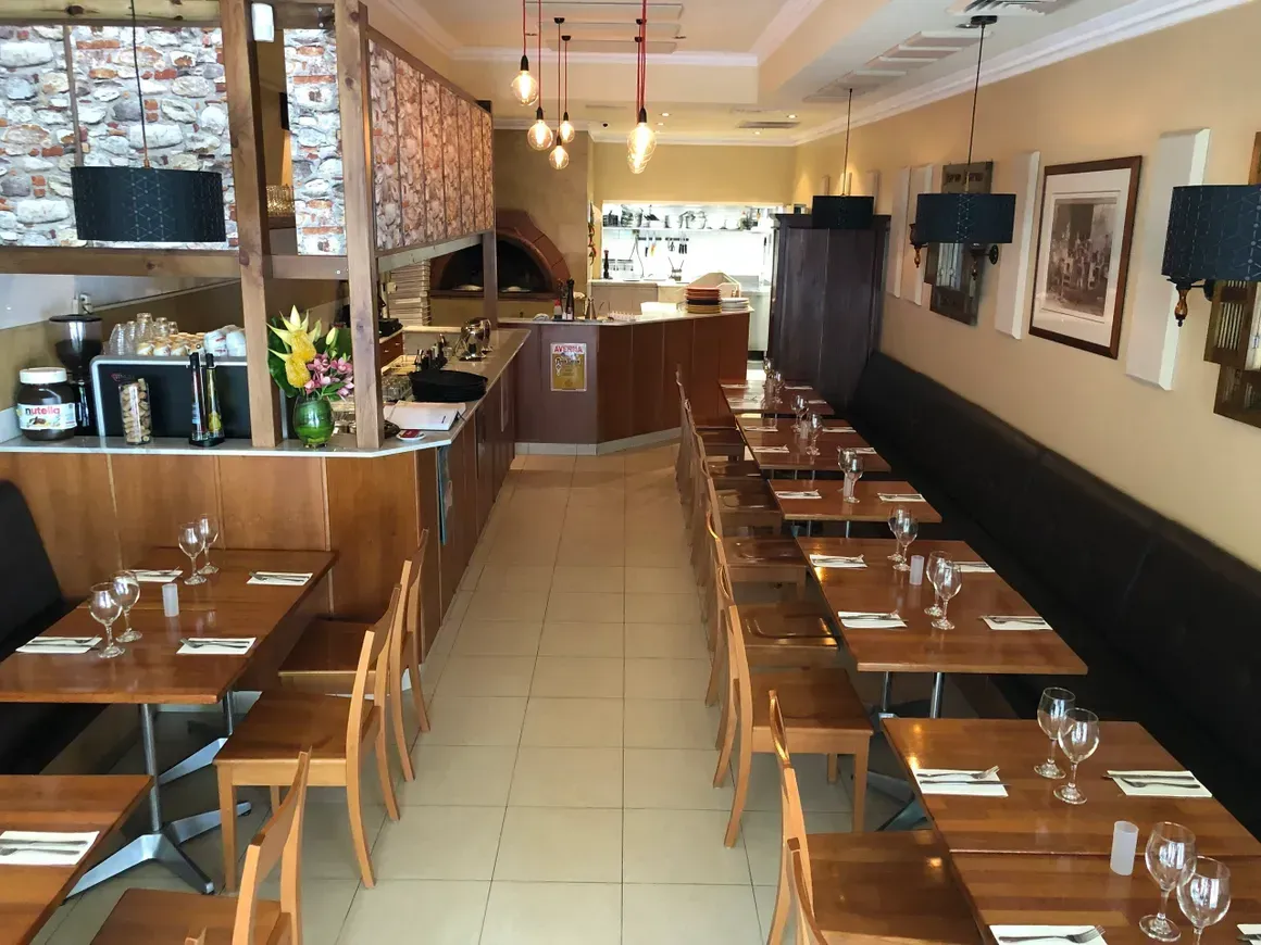 The inside of a restaurant with tables and chairs