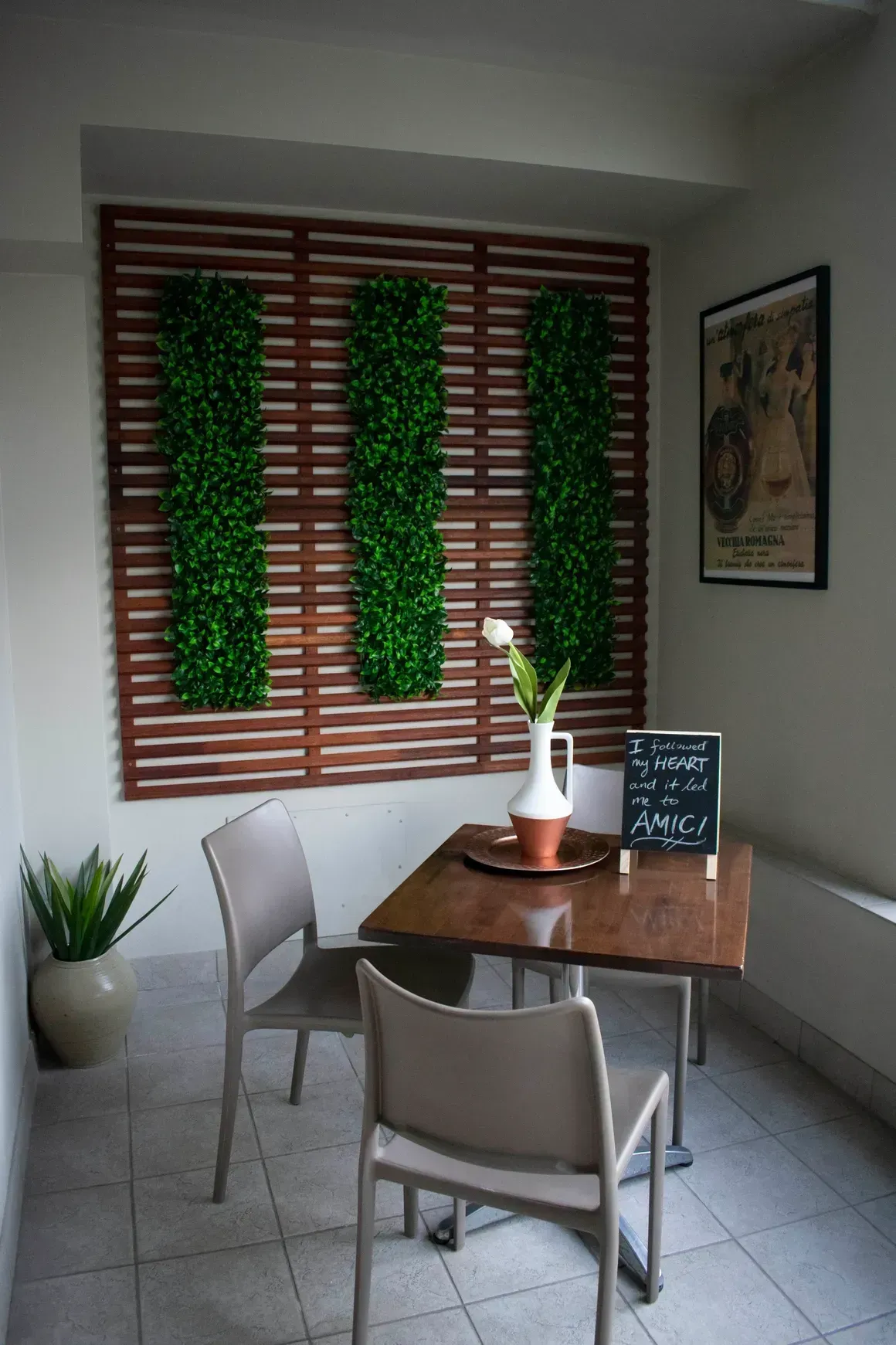 A table and chairs in a room with a chalkboard on the floor.