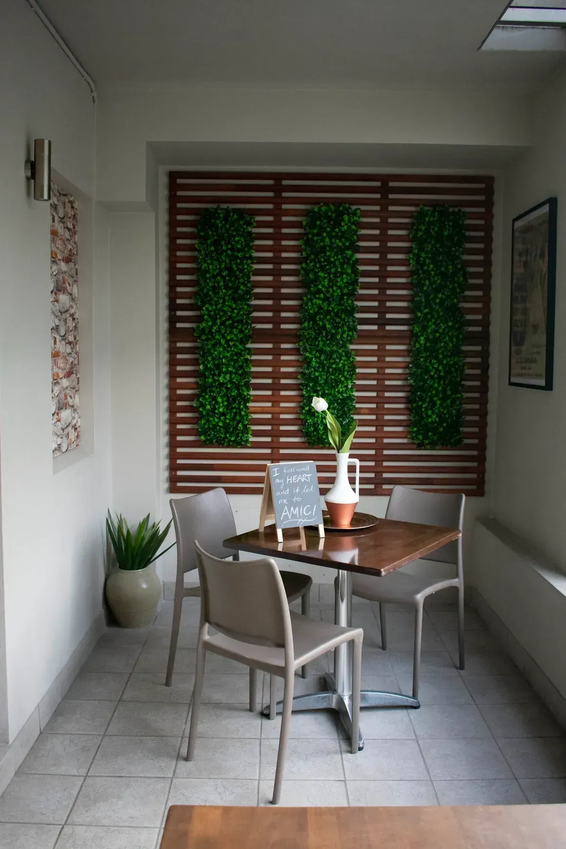 A dining room with a table and chairs in front of a window.