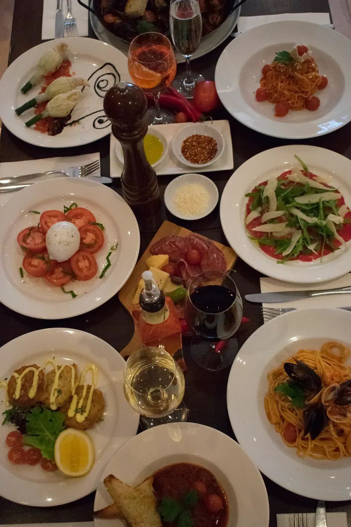 A table topped with plates of food and wine glasses