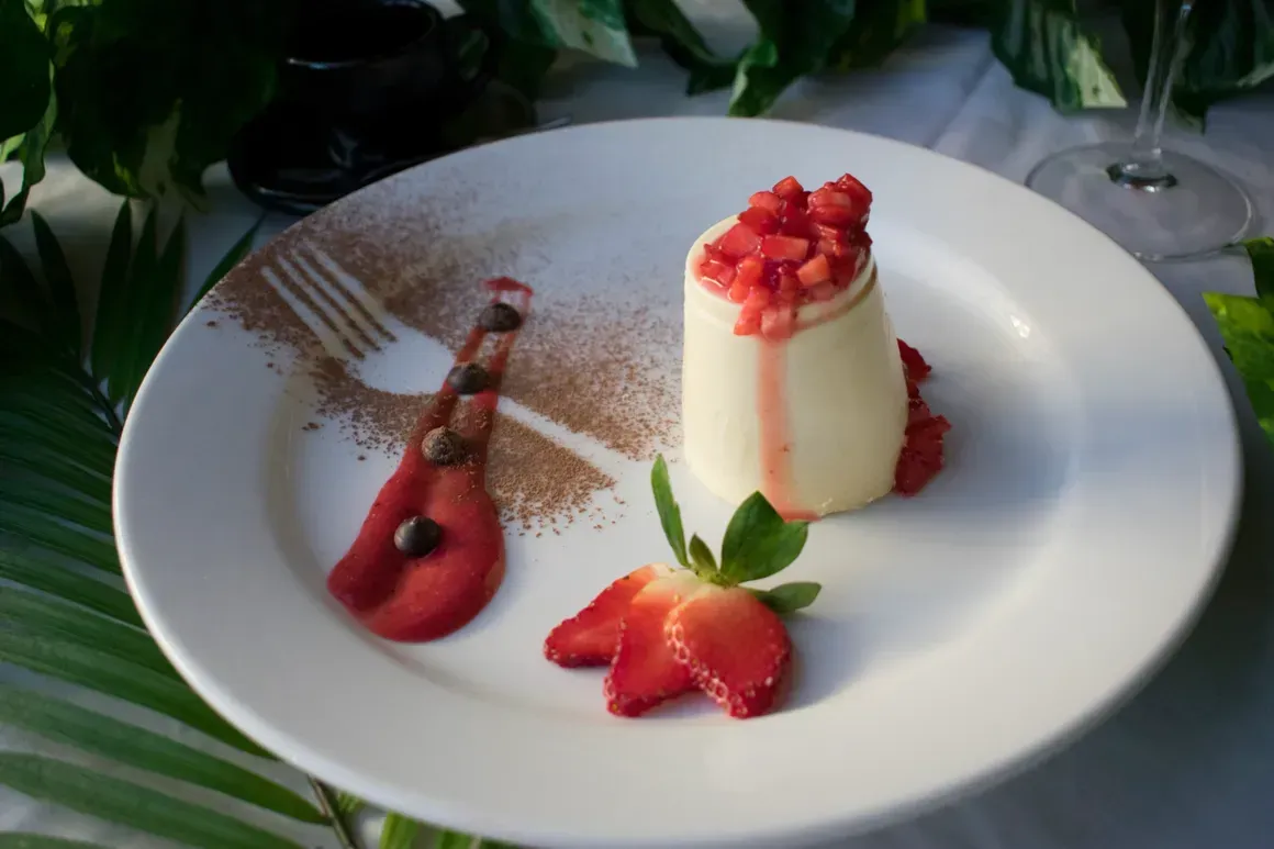 A white plate topped with a dessert with strawberries and a fork
