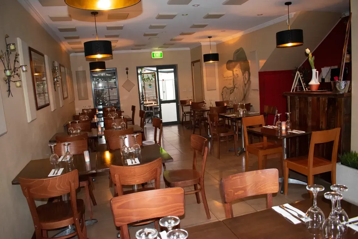 The inside of a restaurant with tables and chairs