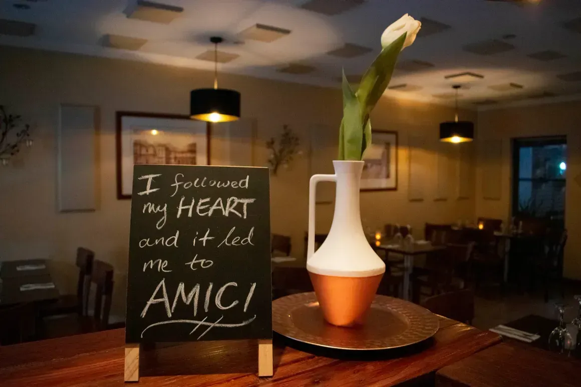 A restaurant with a sign that says i followed my heart and it led me to amici