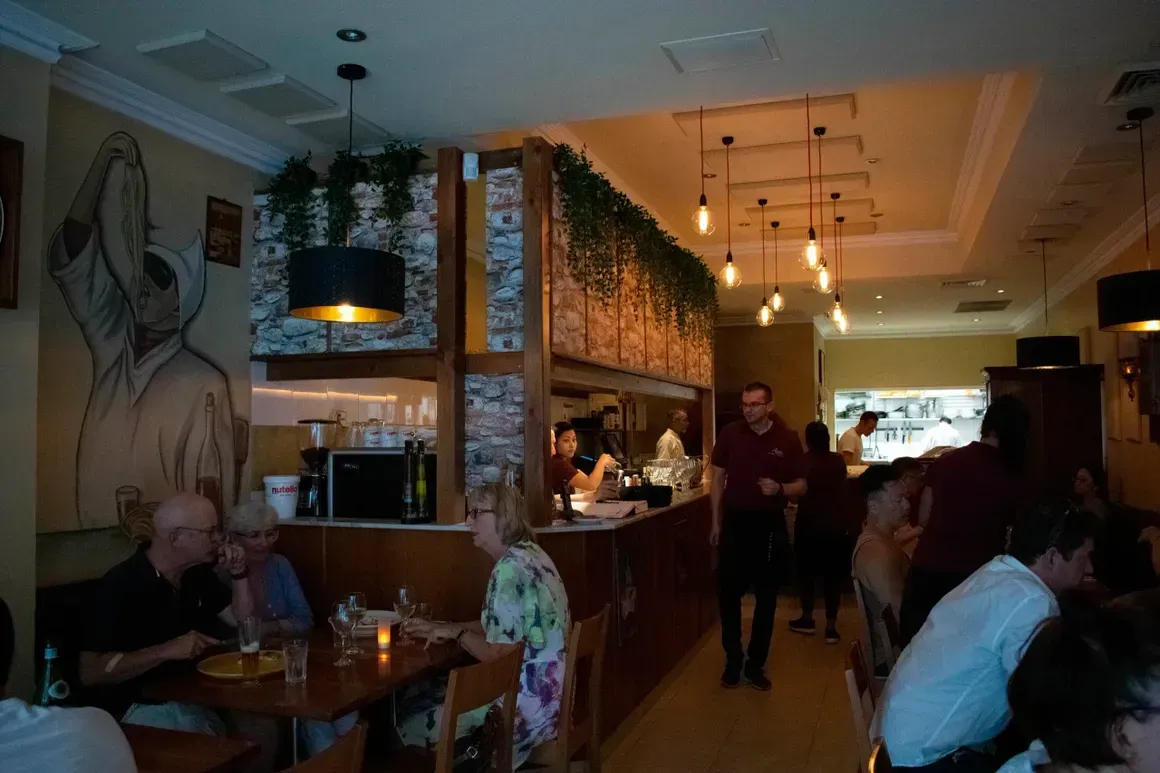 A group of people are sitting at tables in a restaurant.