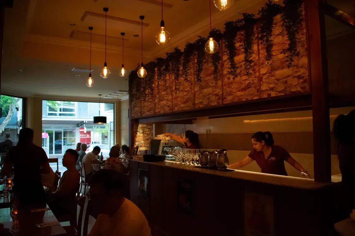 A group of people are sitting at tables in a restaurant.