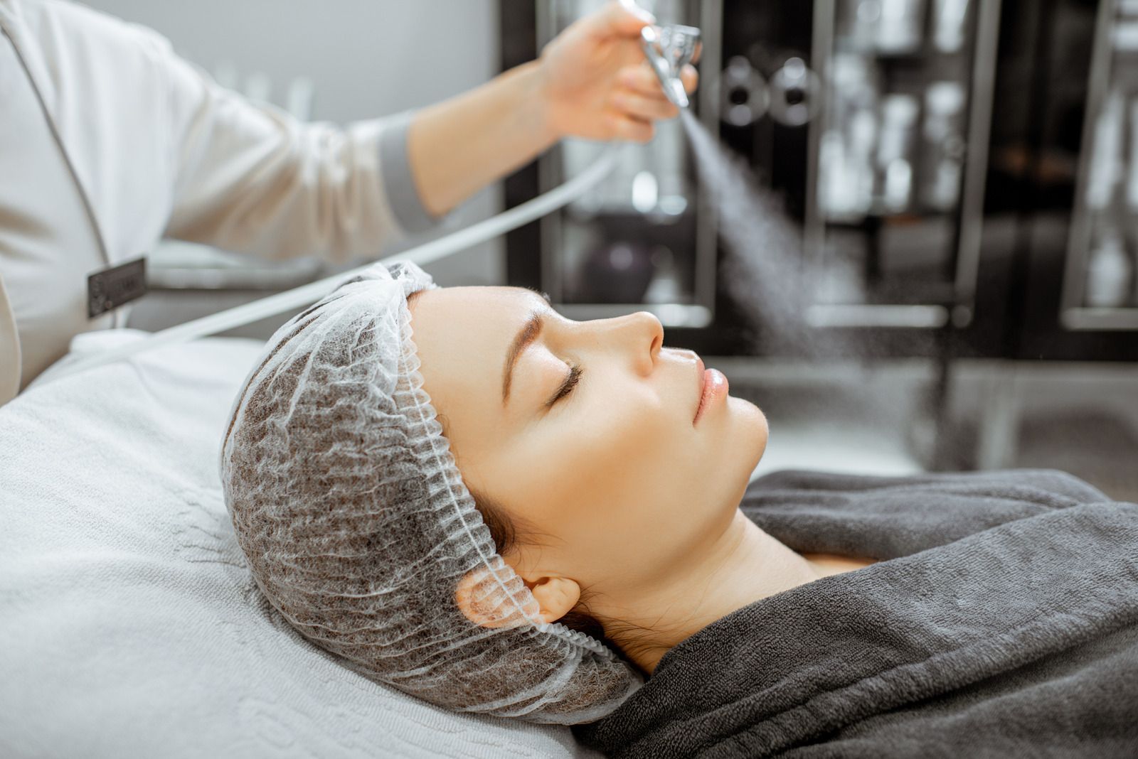 A woman is getting a facial treatment in a beauty salon.