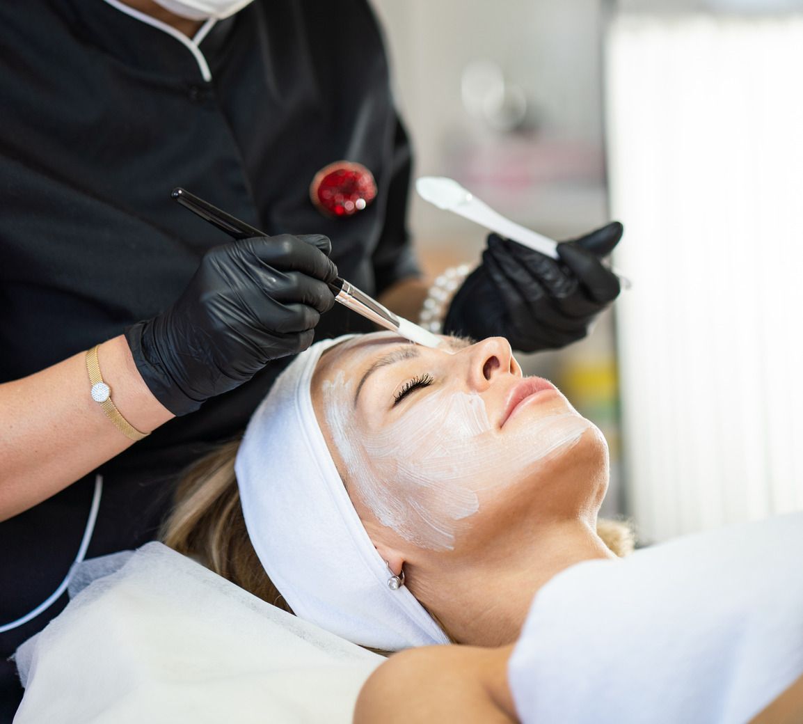 A woman is getting a facial treatment at a beauty salon.