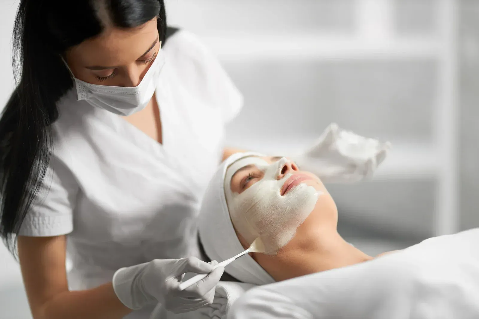 A woman is getting a facial treatment at a beauty salon.