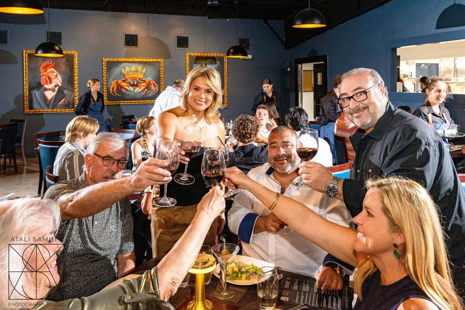 People toasting with wine glasses in a restaurant.