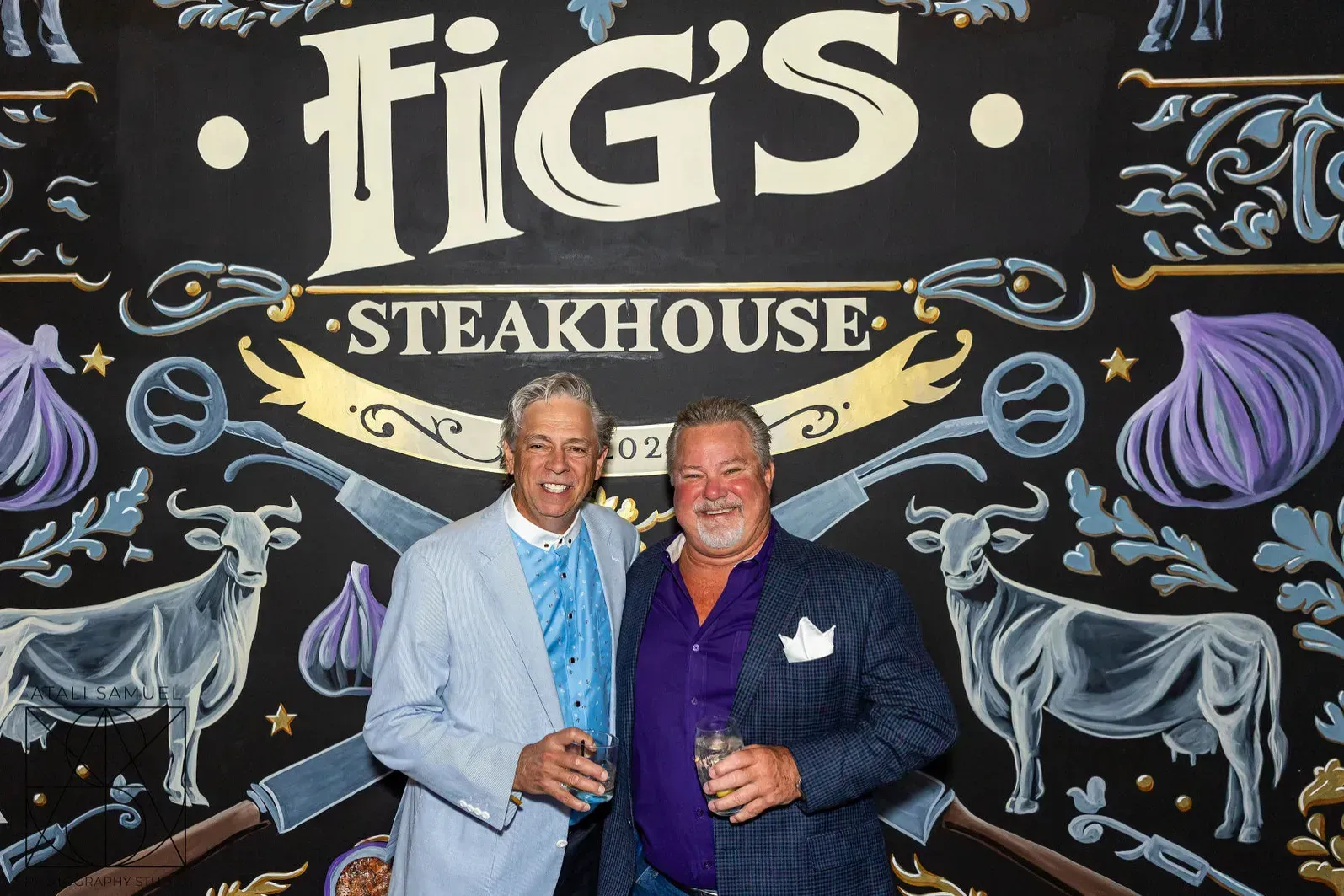 Two men pose in front of a