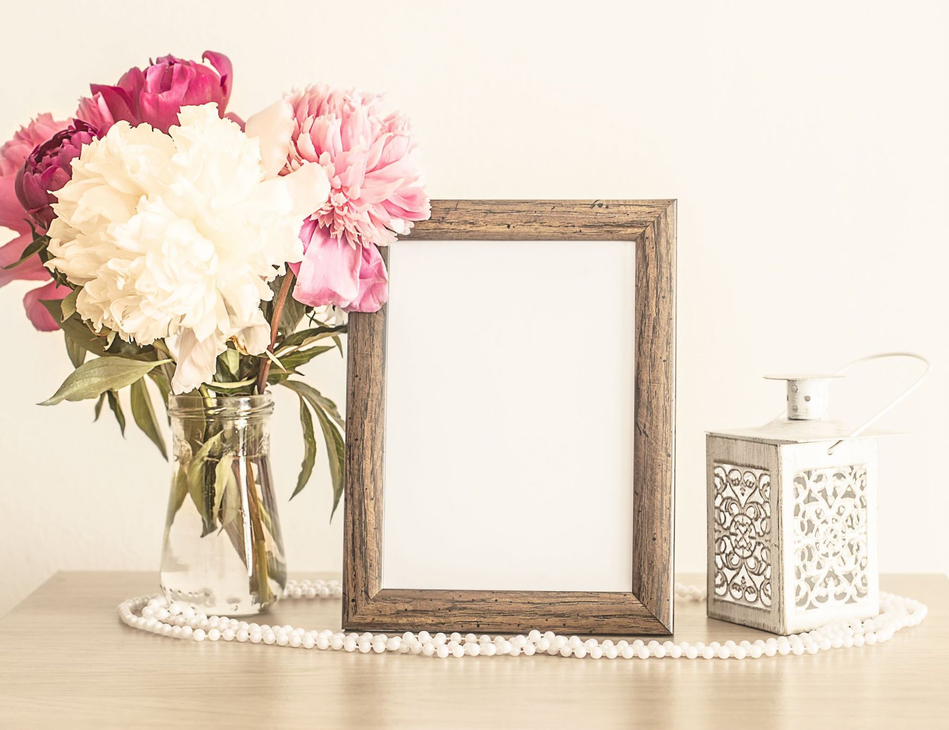 There is a picture frame and a vase of flowers on the table.