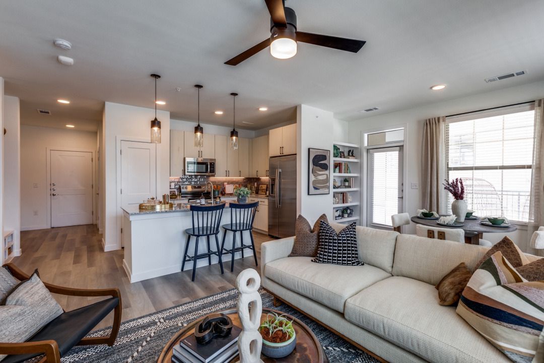 A living room filled with furniture and a ceiling fan.
