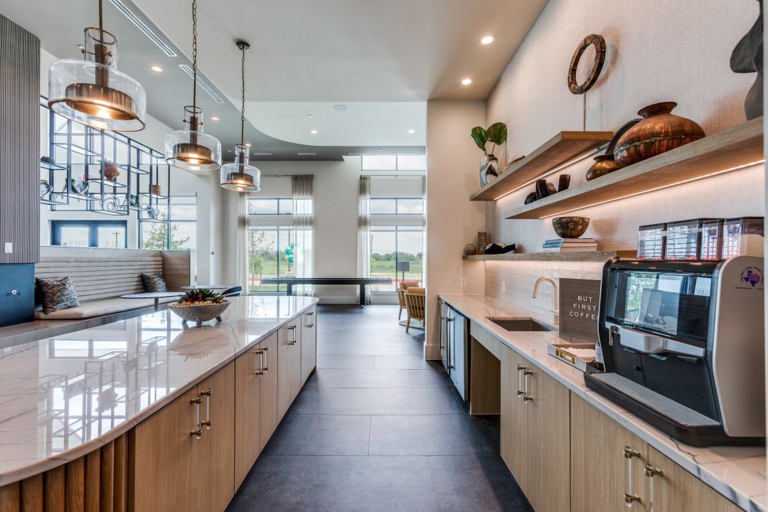 A long kitchen with wooden cabinets and white counter tops.