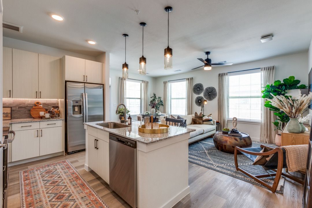 A kitchen with stainless steel appliances and a large island in the middle of the room.