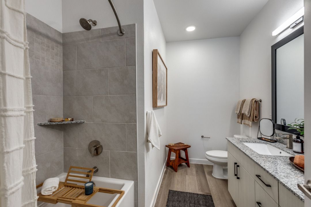 A bathroom with a tub , toilet , sink and shower.