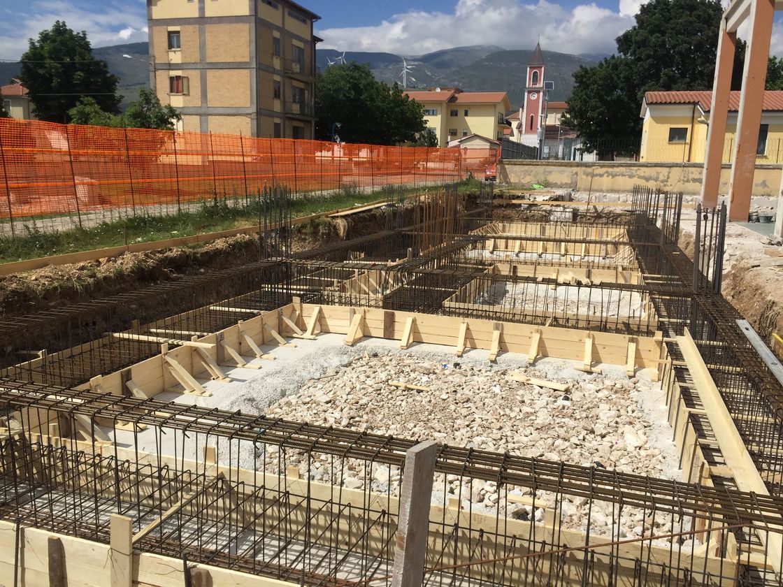 Cantiere con casseforme in legno e barre di armatura per le fondamenta.