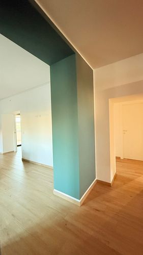 Pannelli solari installati su un tetto di tegole, cielo azzurro, montagne sullo sfondo.