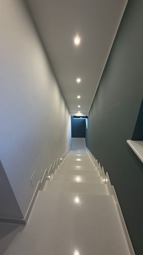 Pannelli solari installati su un tetto di tegole, cielo azzurro, montagne sullo sfondo.