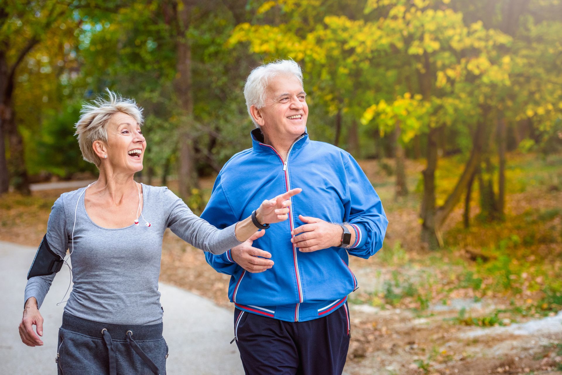 A man and a woman are jogging in a park.