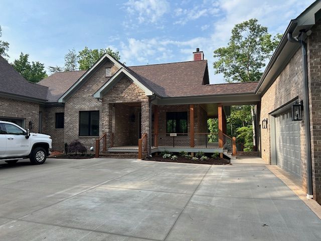 A white truck is parked in front of a brick house