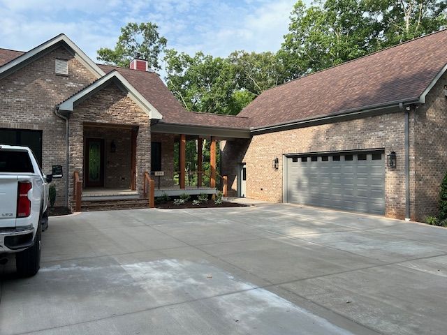 A white truck is parked in front of a large brick house
