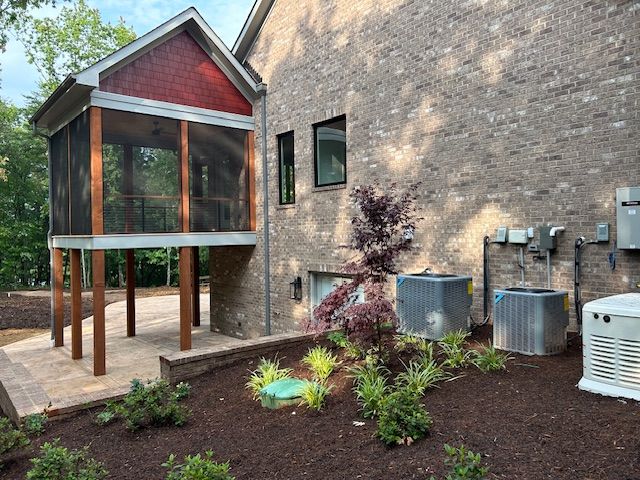 A house with a screened in porch and air conditioners