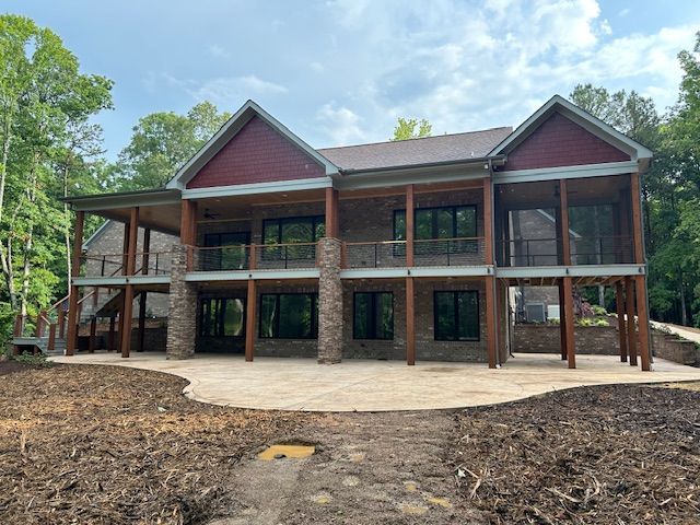 A large house with a lot of windows is sitting on top of a dirt hill.