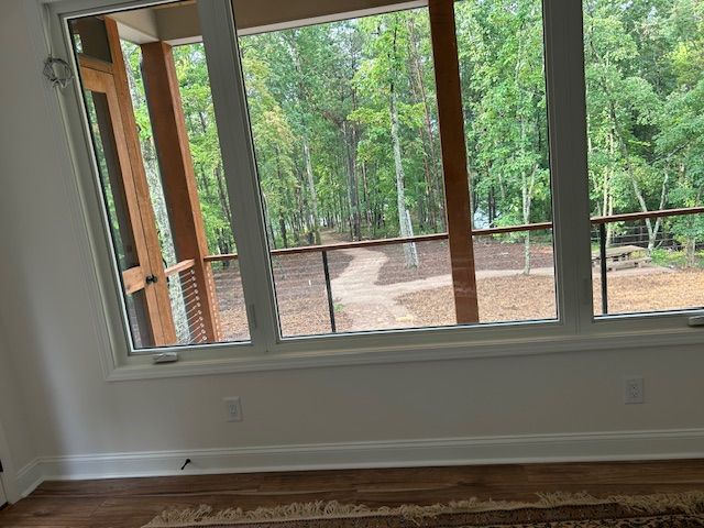 There is a large window in the middle of the room with a view of the woods.