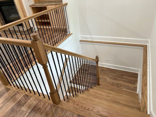 A wooden staircase with a black railing in a house.