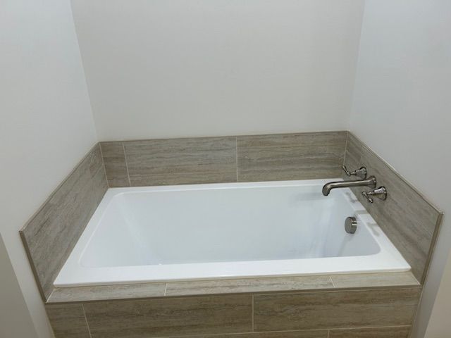 There is a bathtub in the corner of the bathroom.