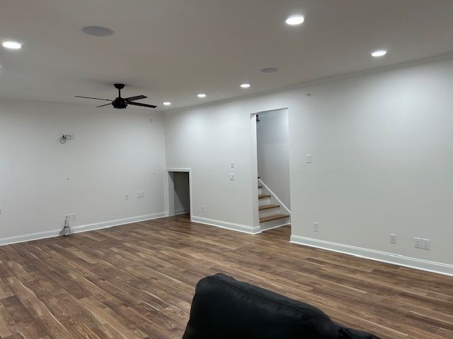 A living room with hardwood floors and a ceiling fan.
