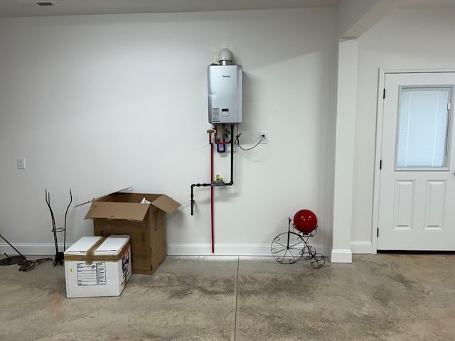 An empty room with a box and a water heater on the wall