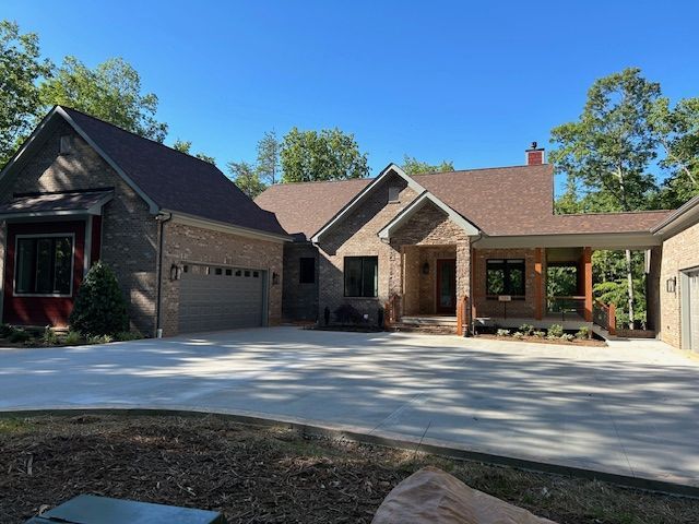 A large brick house with a brown roof and a driveway