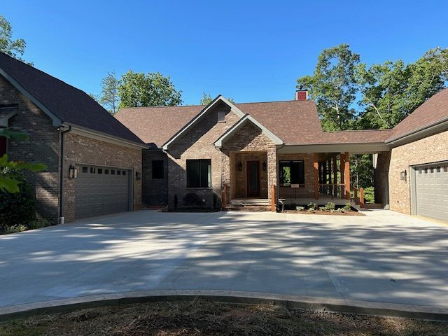 A large brick house with two garages and a driveway
