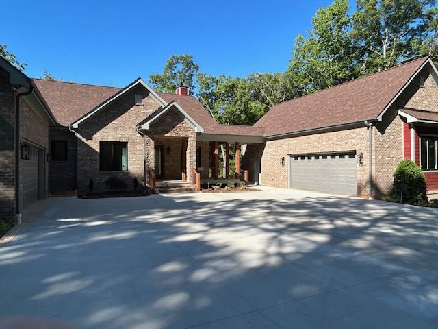 A large brick house with two garages and a driveway