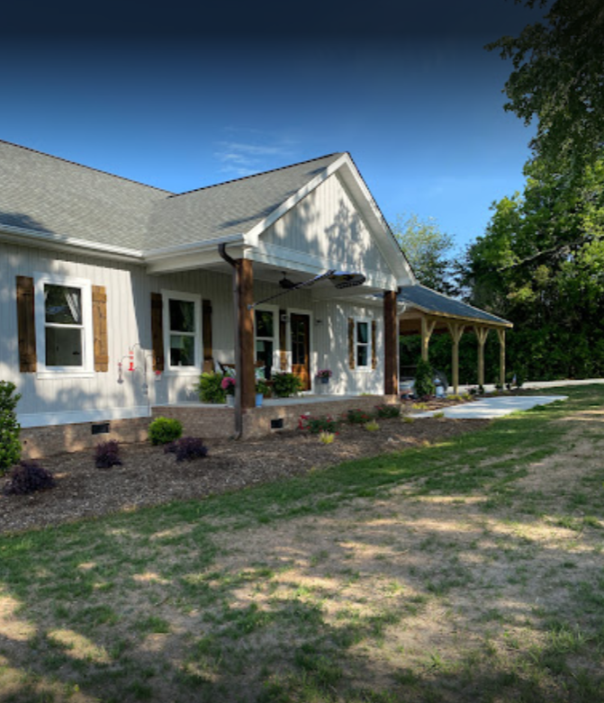 A white house with a porch and a lot of windows