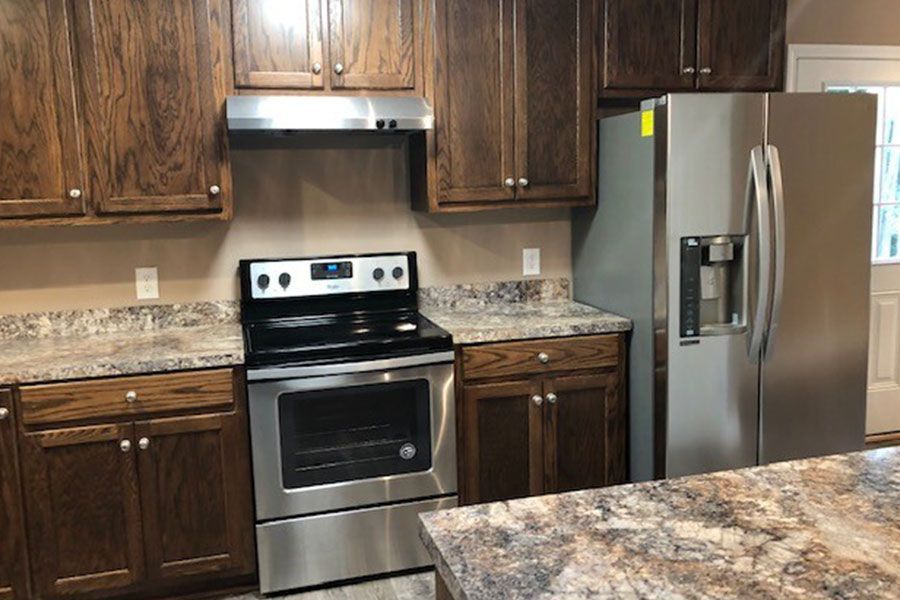 A kitchen with stainless steel appliances and wooden cabinets.