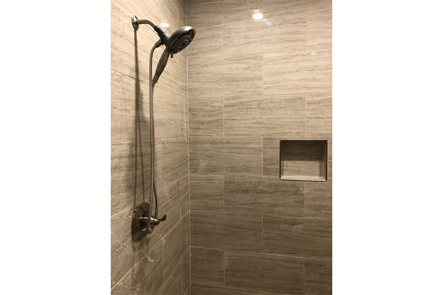 A shower head is hanging from the wall in a bathroom.