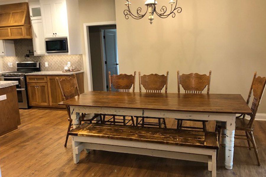 A dining room table with a bench and chairs in a kitchen.