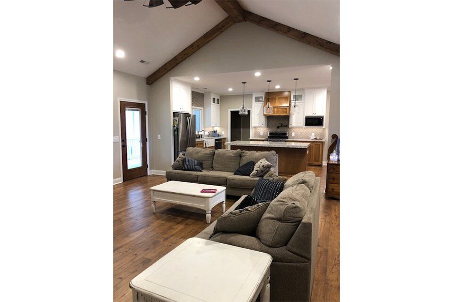 A living room with two couches , a coffee table , and a vaulted ceiling.