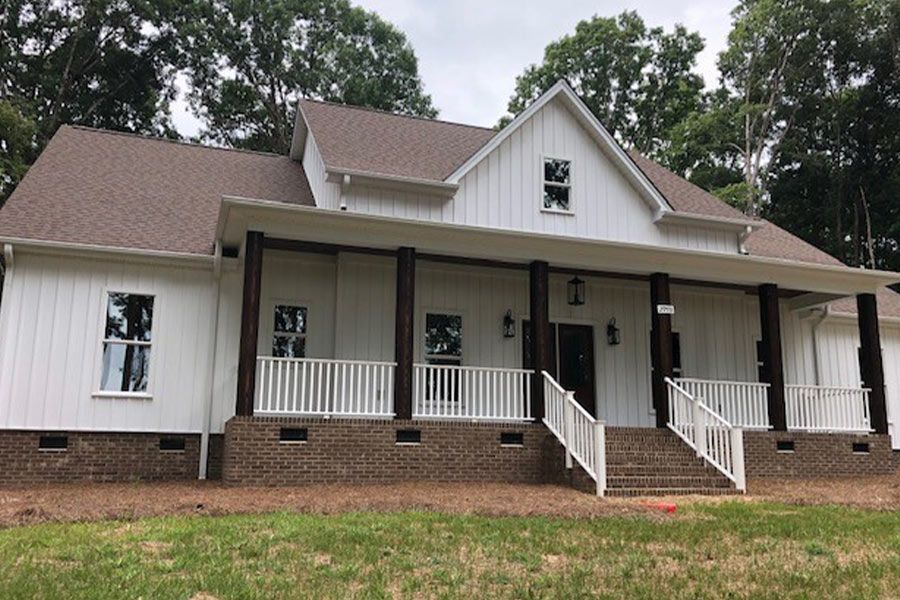 A white house with a large porch and stairs