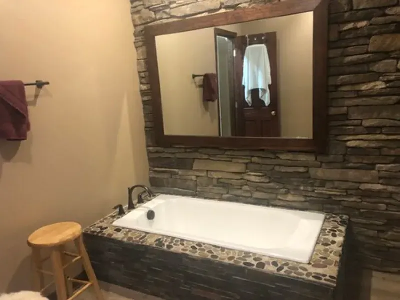 A bathroom with a bathtub and a large mirror