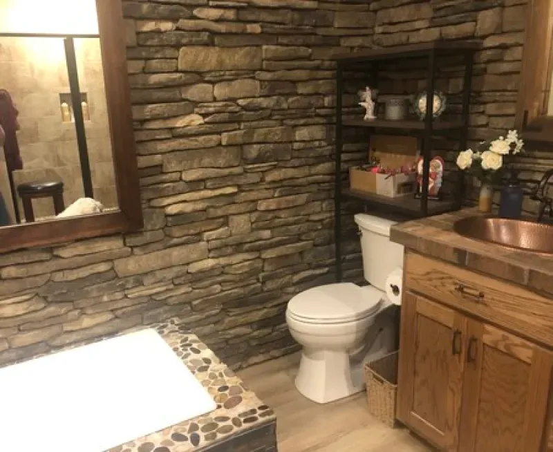 A bathroom with a toilet a sink and a mirror