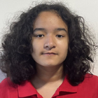 A young girl with curly hair is smiling for the camera.