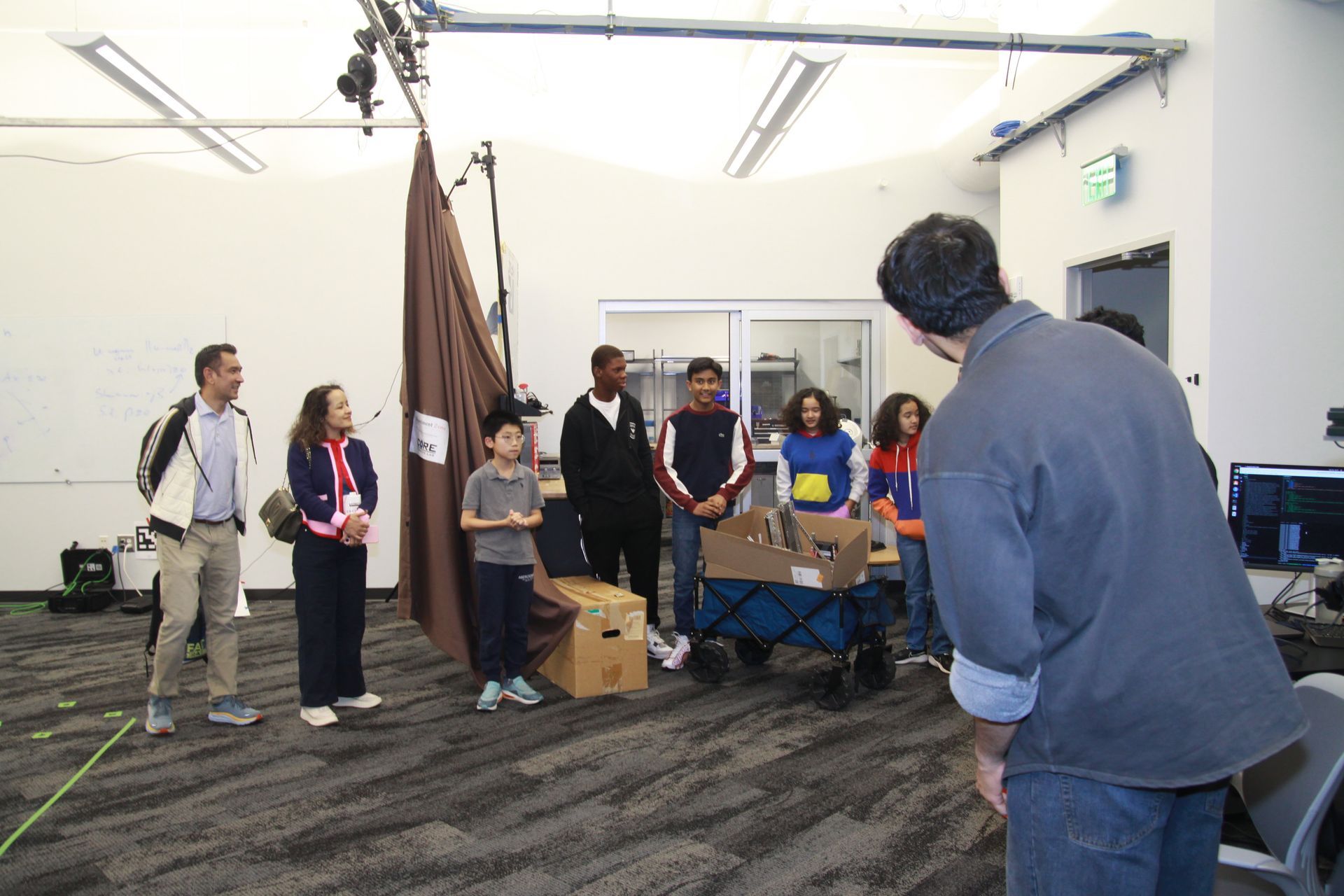 A man is standing in front of a group of people in a room