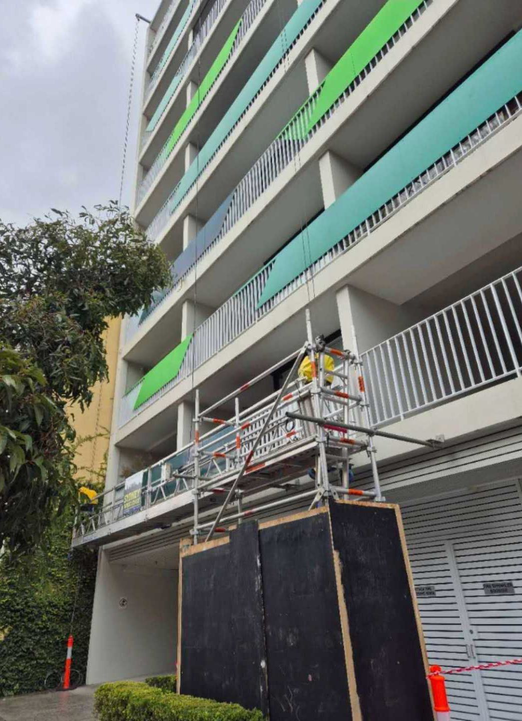 Living room with white sofa, wooden floor, and natural light from a large window with blinds.