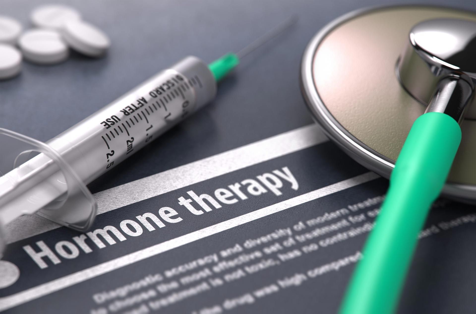 A syringe and stethoscope are on a paper that says hormone therapy