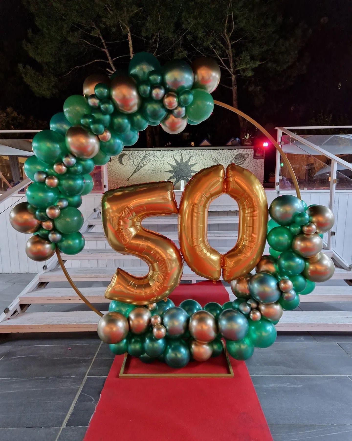 Un palloncino con il numero 50 è circondato da palloncini verdi e oro.