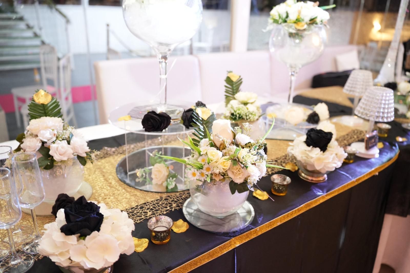 Un tavolo con sopra vasi di fiori e candele.